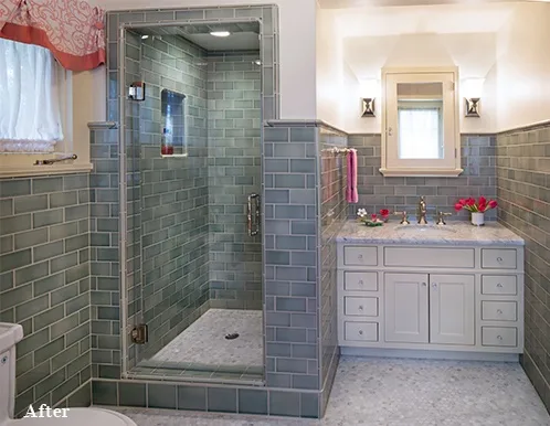 After image of bathroom remodel with continuous tile work and white cabinetry.
